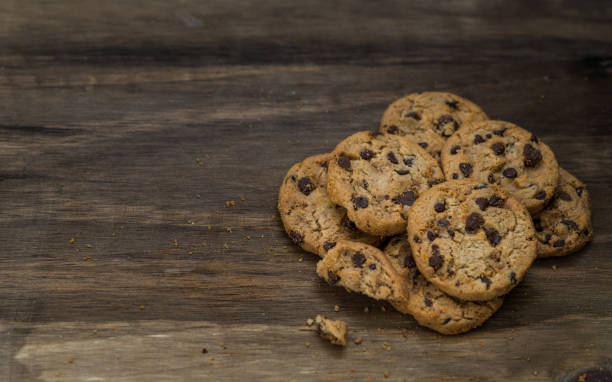 classici biscotti al cioccolato su sfondo ligneo. concetto di dessert, cottura al forno e cibo dolce - quick cookies foto e immagini stock