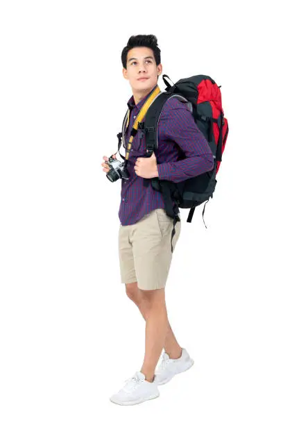 Photo of Isolated Portrait of handsome young asian tourist man with backpack and camera