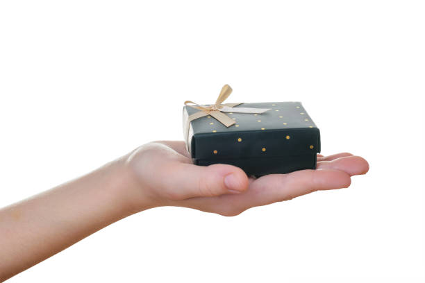 istock Child's right hand with black gift box isolated on white. 1139799361