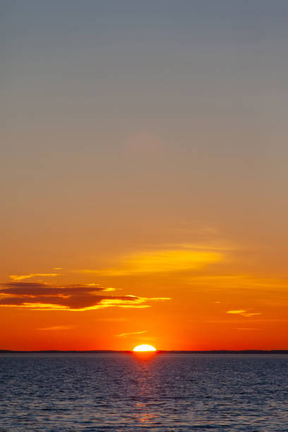 istock bright orange sun with reflection in the water during sunset over the sea 1139800084