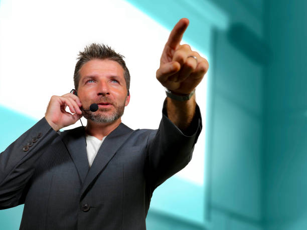 istock young attractive and confident successful man with headset speaking at corporate business coaching and training auditorium conference room talking giving motivation training from speaker stage 1139800800