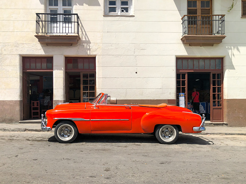 Red classic Cuban vintage car. American classic car on the road in Havana, Cuba.\nFamous car used for sightseeing and taxi in Havana.