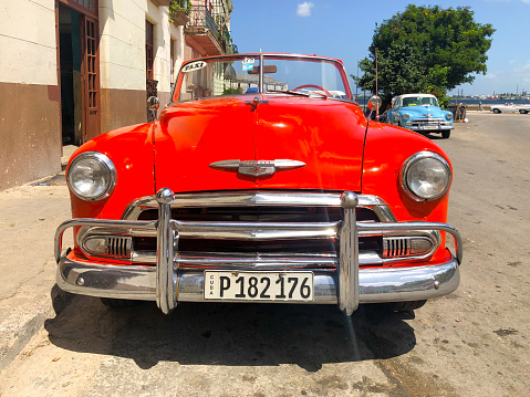 Red classic Cuban vintage car. American classic car on the road in Havana, Cuba.\nFamous car used for sightseeing and taxi in Havana.