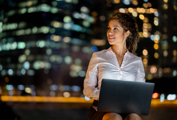 istock Business woman working at night outdoors on a laptop computer 1139805757