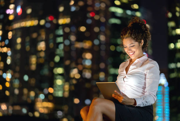 istock Happy business woman at night working online using a tablet computer 1139805764