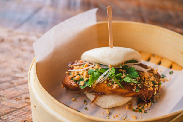 Pork Belly Bao Bun pork belly, Hoisin ginger glaze, crushed peanuts, cilantro, pickles, leeks, and chives hoisin sauce stock pictures, royalty-free photos & images