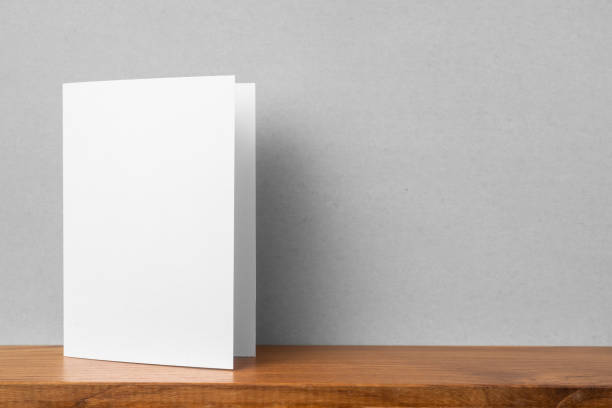 front view of greeting card on bookshelf and grey wall Design concept - front view of greeting card on bookshelf and grey wall for mockup, not 3D render book display stock pictures, royalty-free photos & images