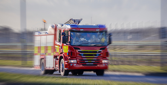 Fire Engine speeding to a call. Blurry background to illustrate urgency