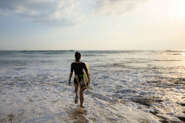 istock Surfer woman walking with surfboard on seaside 1139813920
