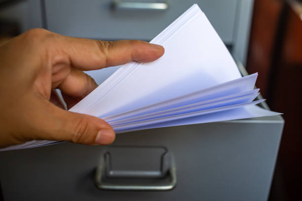 istock Woman's hand pick up white papers for write letter, Filing cabinet with open drawer, Grey silver metal colour, Administration and storage concept, closeup & Macro shot, Selective focus 1139815031