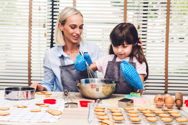 istock Mother and daugthter having fun cooking togather and learning to make a cake while baking in kitchen at home 1139816051