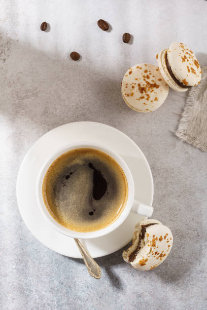 istock Cup of black coffee and chocolate macarons for dessert. 1139818966