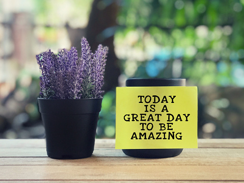 Today Is A Great Day To Be Amazing written on a yellow sticky paper. Blurred styled background.