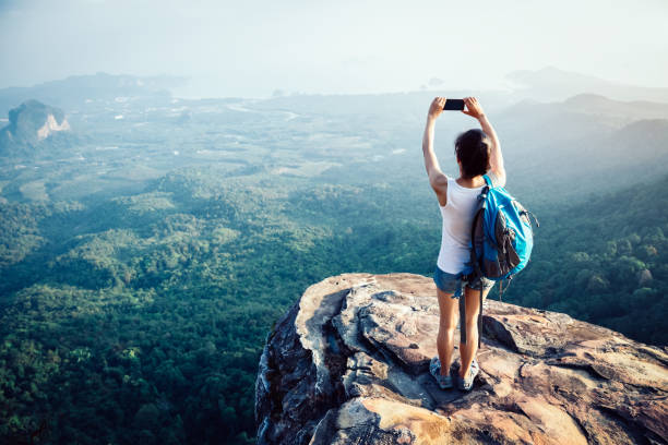 istock woman hiker use her cellphone at  mountain peak cliff edge 1139820363
