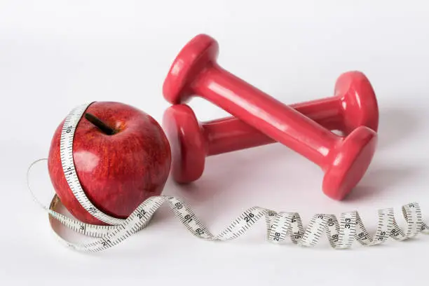apple, tapeline and dumbbells-healthcare concept.
