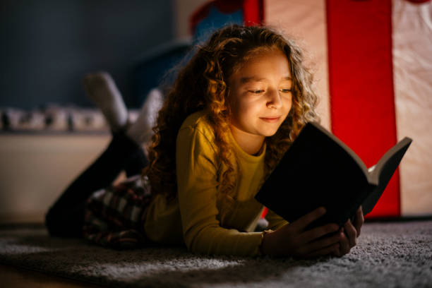 istock Cute Girl Reading a Book at Home 1139821332