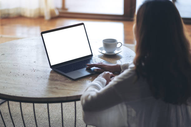 istock Mockup image of a woman using and typing on laptop with blank white desktop screen on the table while sitting on the floor in the house 1139821418