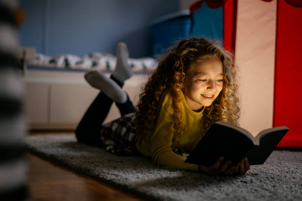 istock Cute Girl Reading a Book at Home 1139821558