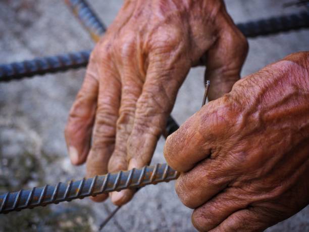 istock close up builder worker hands using wires for knitting metal rods to secure rebar before concrete is poured over it. building construction and industry concept 1139821632