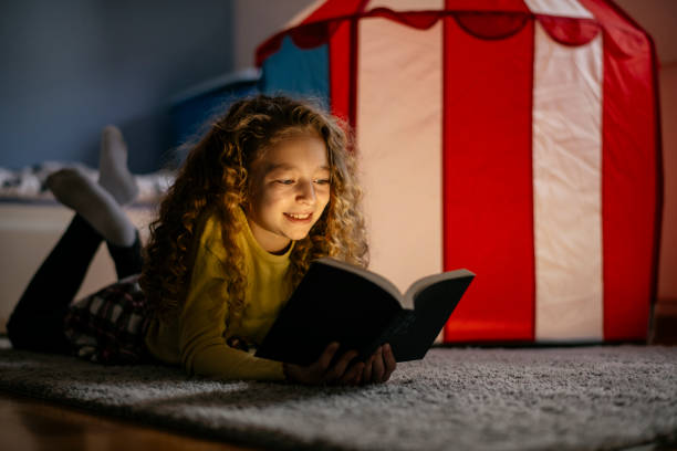 istock Cute Girl Reading a Book at Home 1139822256