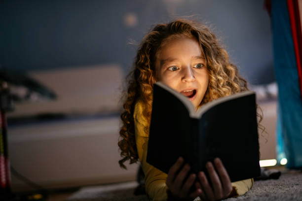 istock Cute Girl Reading a Book at Home 1139822318