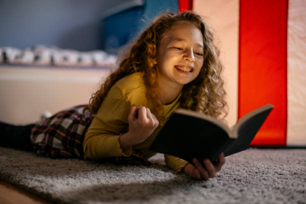 istock Cute Girl Reading a Book at Home 1139822516