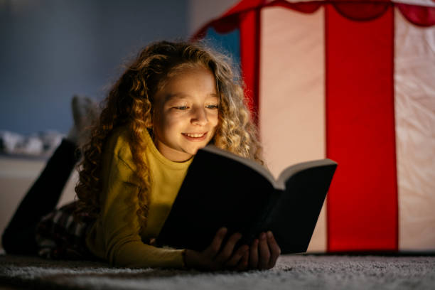 istock Cute Girl Reading a Book at Home 1139822555