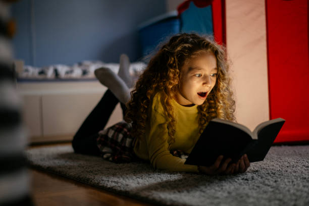 istock Cute Girl Reading a Book at Home 1139823196