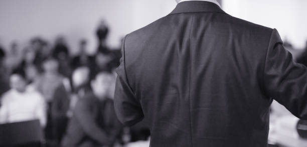 istock Speaker at Talk in Business Conference. Tech Executive Entrepreneur Speaker on Stage at Conference. Presenter Giving Business Presentation at Meeting. Corporate Exhibition for Investors Event. 1139823558