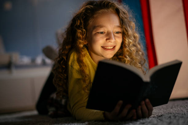 istock Cute Girl Reading a Book at Home 1139823564