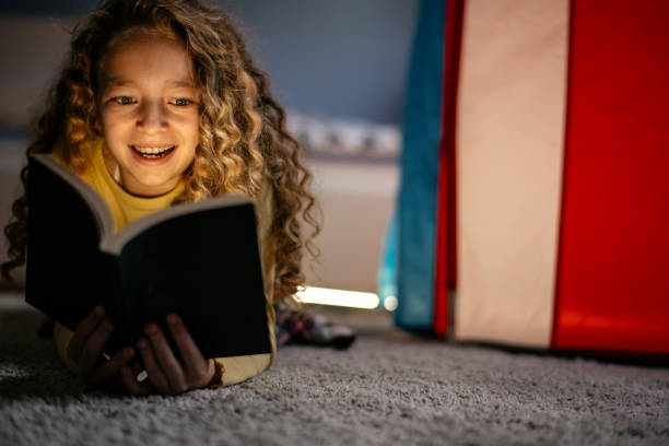 istock Cute Girl Reading a Book at Home 1139824385