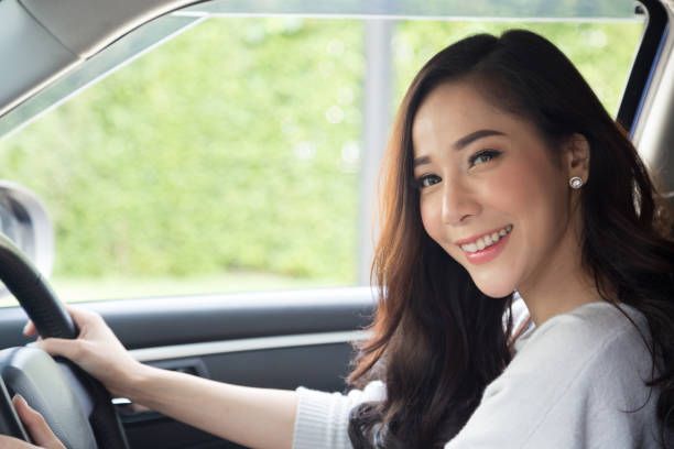 Asian women driving a car and smile happily with glad positive expression during the drive to travel journey, People enjoy laughing and relaxed happy woman on road trip vacation concept, Thai model las mujeres asiáticas conduciendo un coche y sonreír felizmente con la expresión positiva alegre durante el viaje en coche para viajar, la gente disfruta riendo y relajada mujer feliz en el concepto de vacaciones viaje por carretera, modelo tailandés