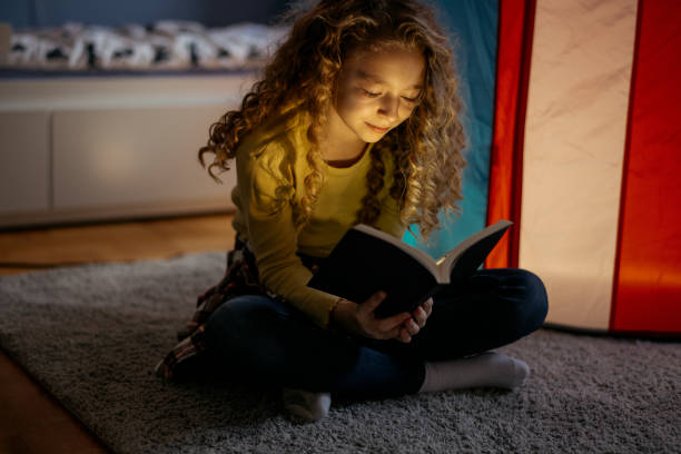 istock Cute Girl Reading a Book at Home 1139825140