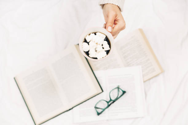 istock Cup  with coffee and in women's hands.Open books,glasses.Top view.White background. 1139828653