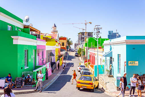 This pic shows colorful township of BoKaap in capetown.  The famous muslim quarter called Bo Kaap in Cape Town, South Africa. This quarter, also called The Malay Quarter, is situated at the foot of signal hill and consits out of lots of colurful houses and mosques. Tourists are strolling around the scenery. The pic is taken in march 2019 in day time.