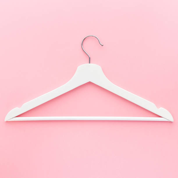 istock White hangers on pastel pink background 1139829777