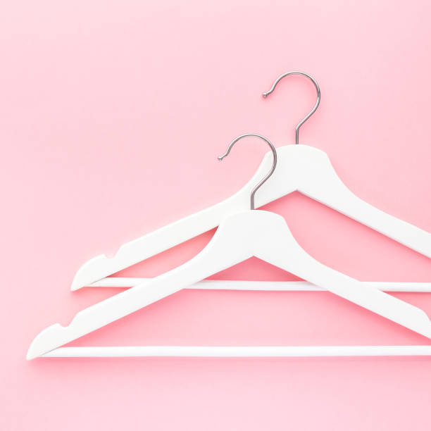 istock White hangers on pastel pink background 1139830855