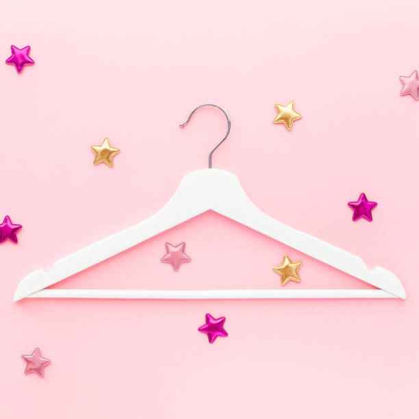 istock White hangers on pastel pink background 1139831963