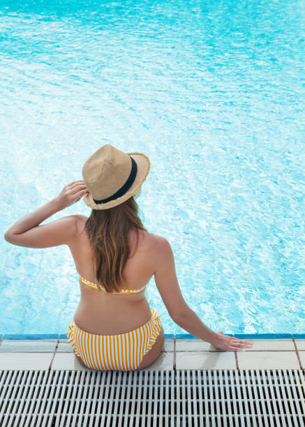 istock Young woman relaxing in swimming pool 1139836445