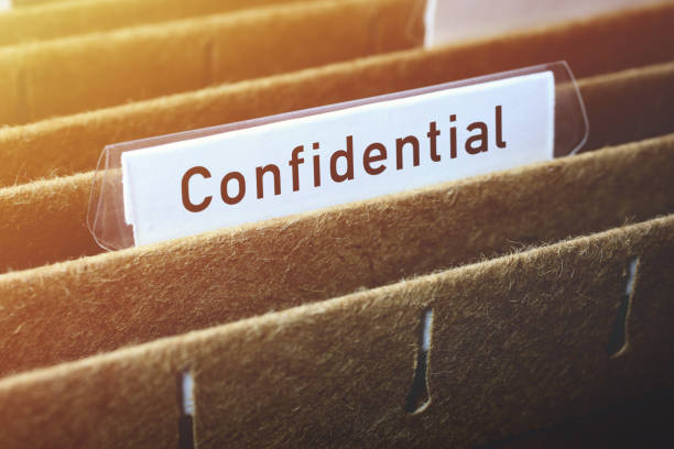 Close-up on hanging file labelled confidential in filing cabinet.