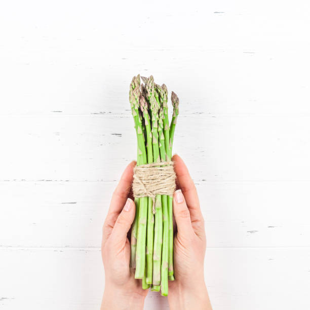 istock Fresh green asparagus in woman hands 1139838559