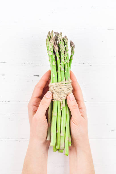 istock Fresh green asparagus in woman hands 1139838579