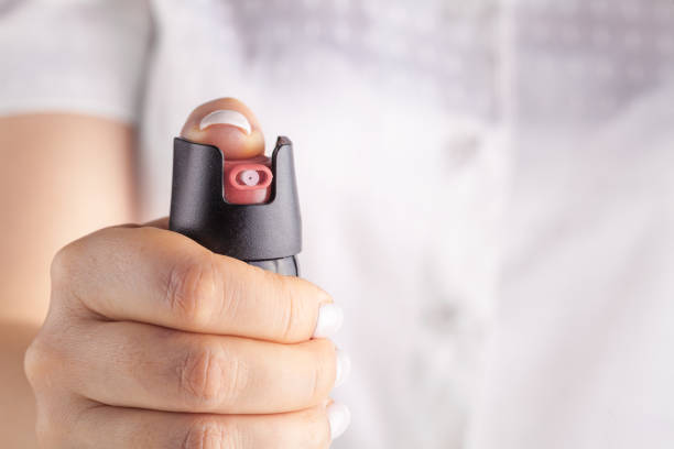 chica dirigió el spray de pimienta a la cámara para la autodefensa - pulverizador de pimienta fotografías e imágenes de stock