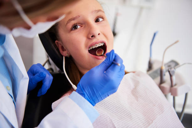 parte do ortodontista que examina os dentes da criança no escritório do dentista - dentists chair dentist office chair orthodontist - fotografias e filmes do acervo
