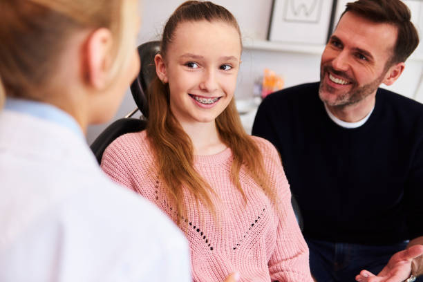 happy girl and her dad during a dental appointment - human teeth child smiling family imagens e fotografias de stock