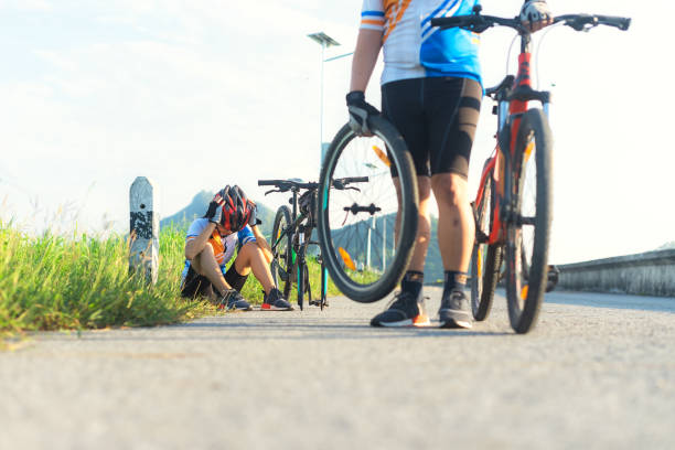 woman cycling has a problem during the way needs flat tire repairing,helping by bicycle mate takes wheel