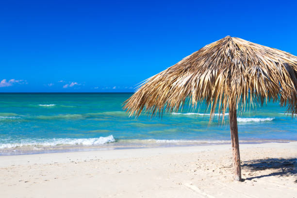 Straw umbrella on empty seaside beach in Varadero, Cuba. Relaxation, vacation idyllic background