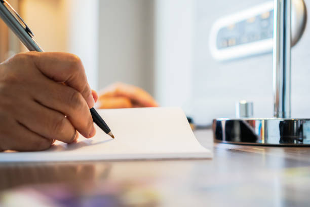 geschäftsmann manager sitzt halten stift für die unterzeichnung der bewerber füllung dokumente berichte papier antragsformular oder die registrierung anspruch auf büro. dokumentenbericht und geschäftliches konzept - legal system business book advice stock-fotos und bilder