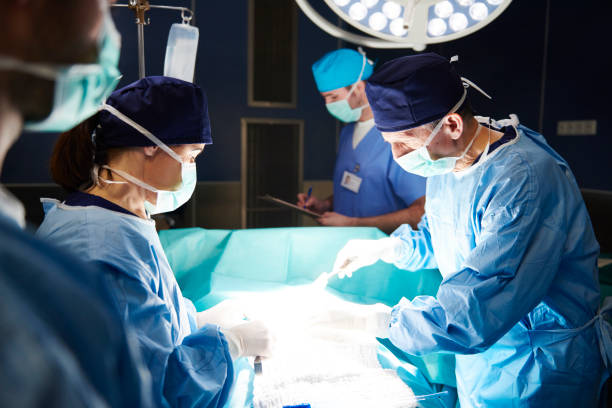 squadra di chirurghi impegnati sul tavolo operatorio - operazione di trapianto foto e immagini stock
