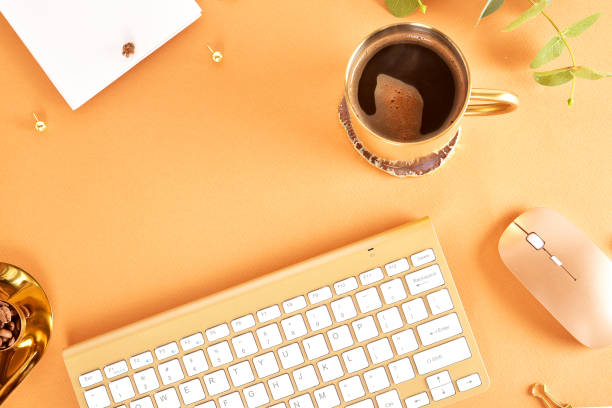 Flat lay. View from above. Business concept with a golden computer keyboard, macarons, a cup of coffee. Place for text.
